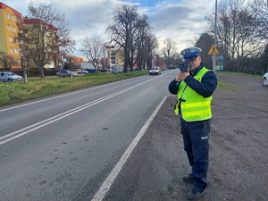 umundurowany policjant wykonuje pomiar prędkości