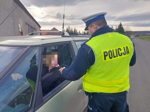 umundurowany policjant bada stan trzeźwości kierowcy