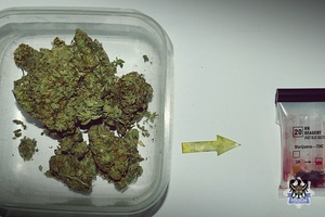 Marihuana w plastikowym pojemniku, obok leży tester narkotykowy