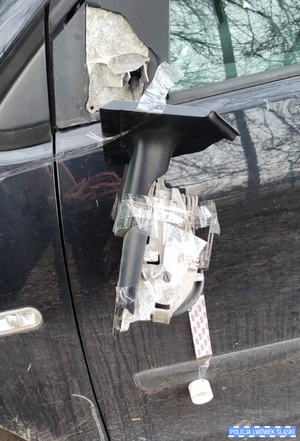 urwane lusterko samochodowe wiszące na kawałkach taśmy klejącej przy drzwiach samochodowych