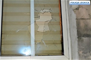 Uszkodzone szyby w oknach kamienicy i pojeździe osobowym