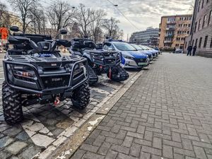 Na zdjęciu stojące w w jednej linii przed budynkiem komendy nowe quady, motory i samochody policyjne.