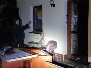 Na zdjęciu mężczyzna pokazujący okno, przez które dokonano włamania.