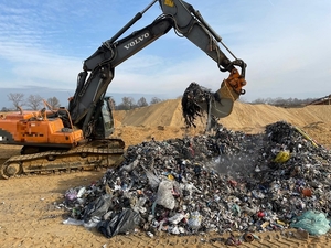 Na zdjęciu koparka przerzucająca nielegalne odpady.