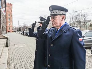 Komendant Wojewódzki Policji we Wrocławiu - nadinspektor Dariusz Wesołowski oddaje honor przed pamiątkową tablicą patrona dolnośląskiej jednostki.