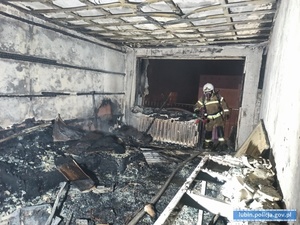 Na zdjęciu strażak stojący w spalonym pomieszczeniu.