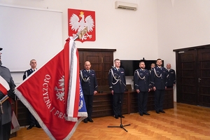 kadra kierownicza policji stojaca na tle sztandaru