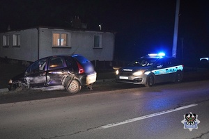 Na zdjęciu samochód, który uderzył w mur,a za nim stojący na sygnałach radiowóz.