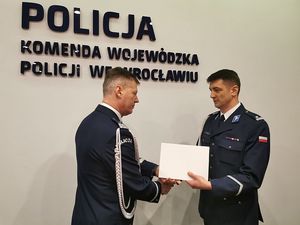 Na zdjęciu policjant odbiera gratulacje od nadinspektora Dariusza Wesołowskiego.