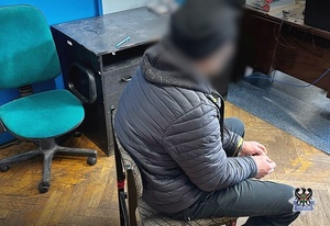 zatrzymany mężczyzna siedzi na krześle podczas wykonywania czynności