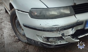 Na zdjęciu zniszczony przód zderzaka srebrnego samochodu osobowego.