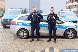 Na zdjęciu funkcjonariusze wydziału prewencji Piotr Czycz i Karolina Kaźmierska na tle trzech radiowozów.