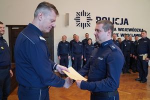 Na zdjęciu nadinspektor Dariusz Wesołowski przekazuje gratulacje policjantowi.
