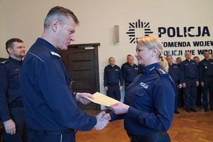 Na zdjęciu nadinspektor Dariusz Wesołowski przekazuje list gratulacyjny policjantce.