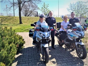 Policjanci z personelem medycznym przy policyjnych motocyklach