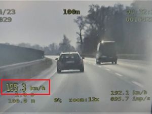 samochód na drodze, w lewym dolnym rogu zakreślony czerwoną ramką napis 195.3 km/h