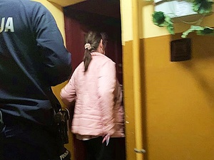 Policjant z odnalezioną kobietą wchodzą do pomieszczenia.