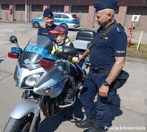 Policjant i dziecko przy motocyklu policyjnym
