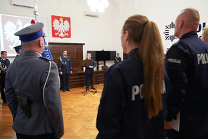 Na zdjęciu przemawiający ksiądz protojerej Grzegorz Cebulski, na pierwszym planie poczet sztandarowy i nowo przyjęci policjanci.