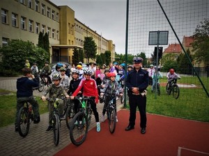 Na zdjęciu dzieci na rowerach z policjantem podczas egzaminu na kartę rowerową.