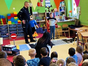 policjant przemawia do dziećmi podczas zajęć edukacyjno-informacyjnych