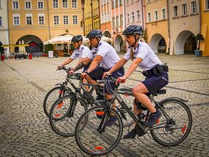 Na zdjęciu dwie policjantki i policjant jadący na rowerach (zdjęcie z boku).