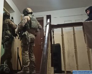 Na zdjęciu policjanci Samodzielnego Pododdziału Kontrterrorystycznego stojący przy drzwiach do mieszkania.