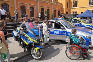Na zdjęciu dzieci oglądający radiowozy i motory policyjne.