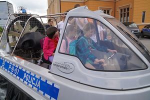 Na zdjęciu dzieci siedzą w policyjnej motorówce.