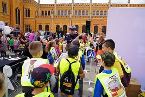 Na zdjęciu policjant ruchu drogowego rozmawia z dziećmi.