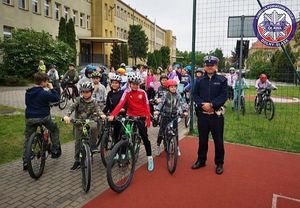Wspólne zdjęcie policjanta i dzieci na rowerach