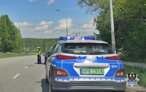 Na zdjęciu radiowóz w tle policjant kontrolujący pojazd