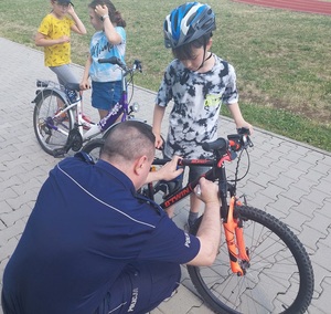 Policjant znakuje rower chłopca.