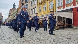 Orkiestra policyjna maszeruje po Wrocławskim Rynku.