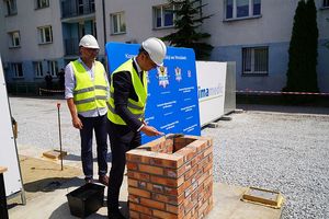 Wiceprezydent Wrocławia Pan Jakub Mazur w towarzystwie przedstawiciela firmy budowlanej podczas wmurowania tuby - kapsuły czasu.
