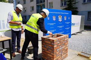 Wojewoda Dolnośląski Pan Jarosław Obremski w towarzystwie przedstawiciela firmy budowlanej podczas wmurowania tuby - kapsuły czasu.