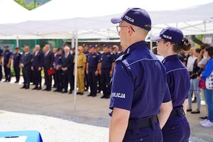 Na pierwszym planie policjant i policjantka, w tle uczestnicy uroczystości.