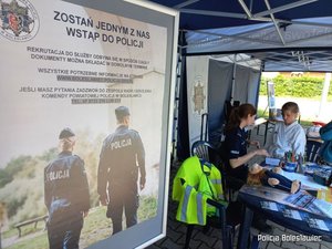 Baner policyjny informujący o naborze, w tle policjantka z dzieckiem.