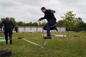 Policjant skacze przez płotek.