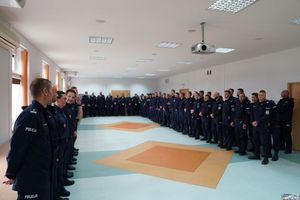 Uczestnicy konkursu par patrolowych policji stojący w dwuszeregu w pomieszczeniu.