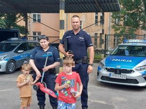 Policjanci stoją z odnalezionymi dziećmi