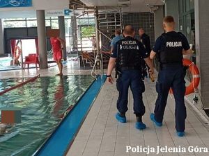 Policjanci z ratownikami przy basenie