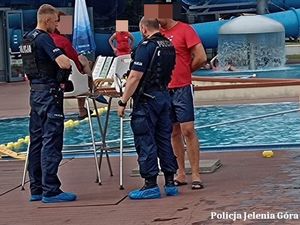 Policjanci z ratownikami przy basenie