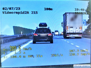 Zdjęcie z wideorejestratora przedstawiające, jak samochód osobowy przekracza prędkość. Na zdjęciu 209,6 kilometrów na godzinę.