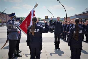 Przedstawiciele nowo przyjętych policjantów ślubujący na sztandar.