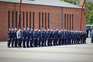 Nowo przyjęci policjanci stojący w dwuszeregu.