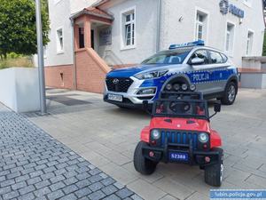 Radiowóz i dziecięcy samochód elektryczny.