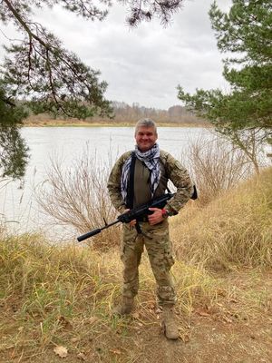 Dowódca Samodzielnego Pododdziału Kontterrorystycznego Policji we Wrocławiu stoi z długą bronią, w tle widać jezioro