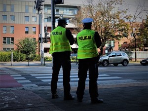 Policjanci ruchu drogowego stojący przed przejściem dla pieszych