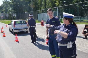 Policjantka kieruje ruchem po wypadku drogowym